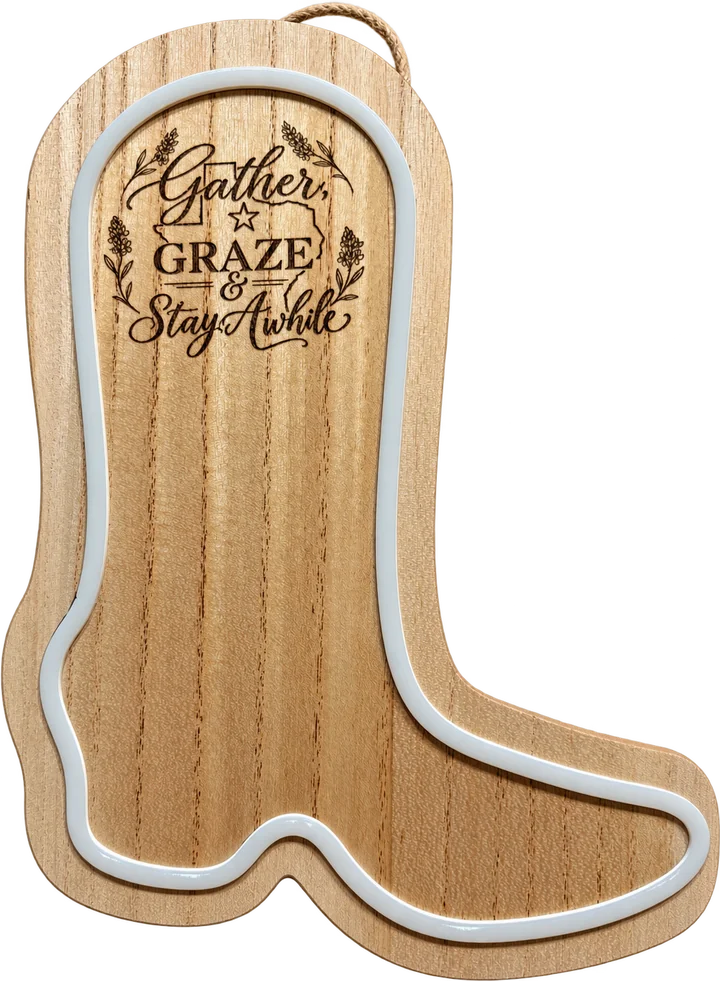 Wood cowboy boot sign engraved with Gather, Graze and Stay Awhile and outlined with a neon strip